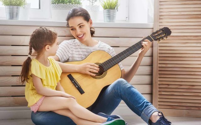 Mom and daughter playing guitar