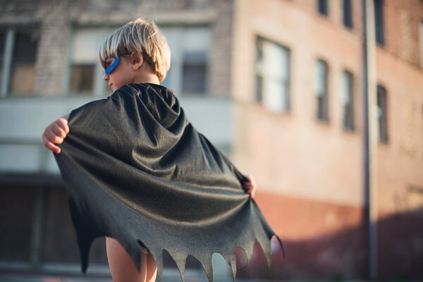 Young child with super hero cape.