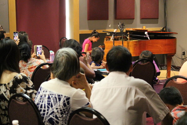 Little girl at piano recital